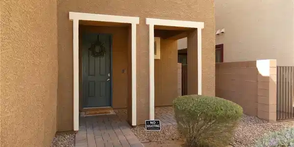 Image 2: A welcoming front entry features a paved pathway l