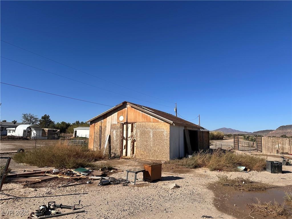 Image 2: A rustic storage shed sits on a spacious, uncultiv