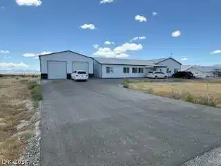 Image 2: An expansive asphalt driveway leads to a large, fu