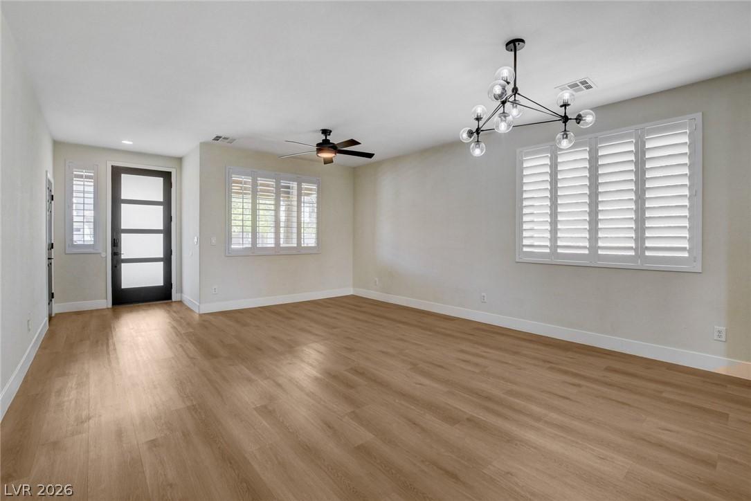 Image 4: A well-lit living space with durable plank floorin