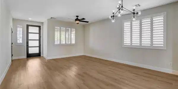 Image 4: A well-lit living space with durable plank floorin