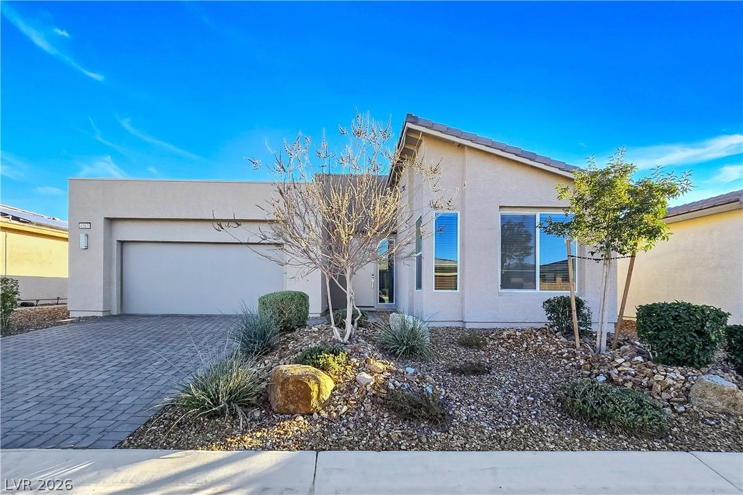 Image 2: A contemporary desert-style home with a paver driv