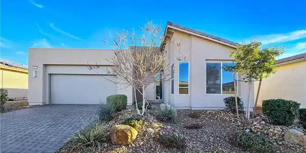 Image 2: A contemporary desert-style home with a paver driv