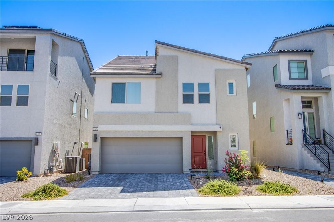 Image 2: View of front of property with a garage, stucco si