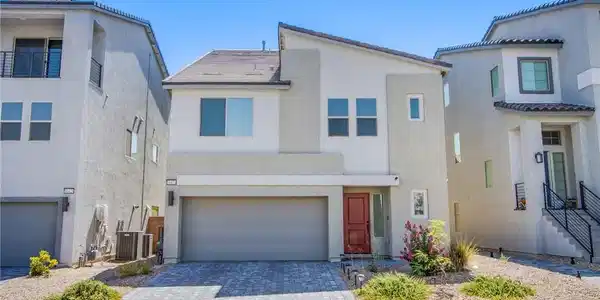 Image 2: View of front of property with a garage, stucco si
