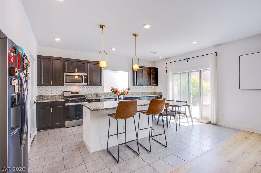 Image 3: Kitchen featuring dark wood finish cabinets, stain