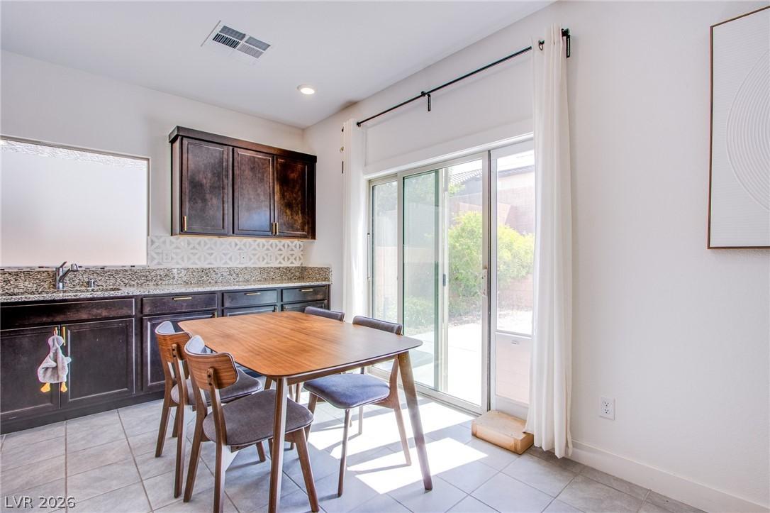 Image 4: Dining room with light tile patterned floors and r