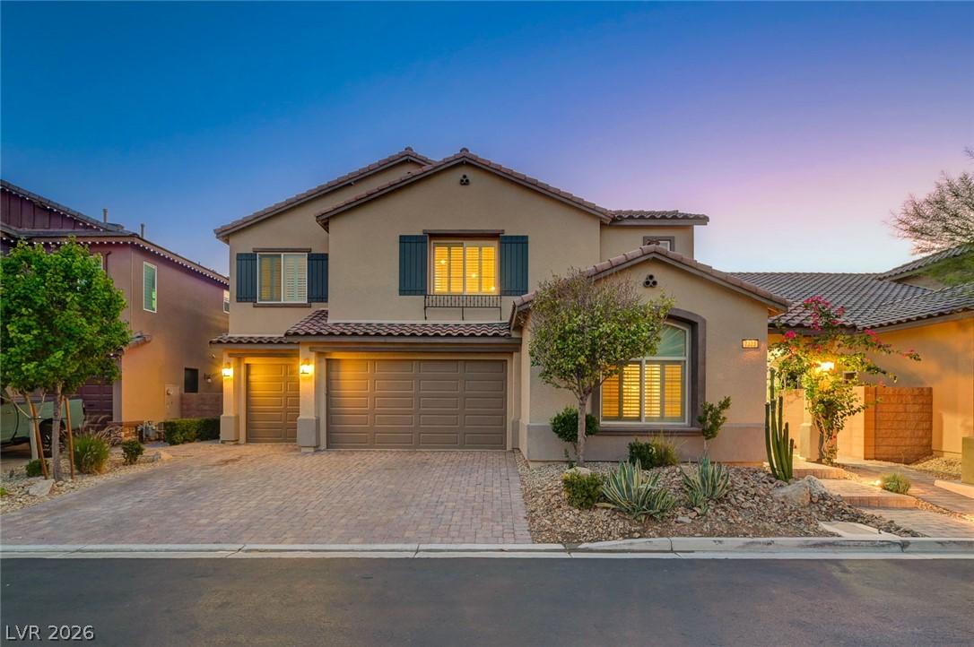 Image 2: A Mediterranean-style residence presents a paved d