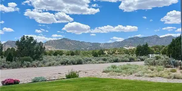 Image 2: Expansive green lawn fronts a picturesque, distant