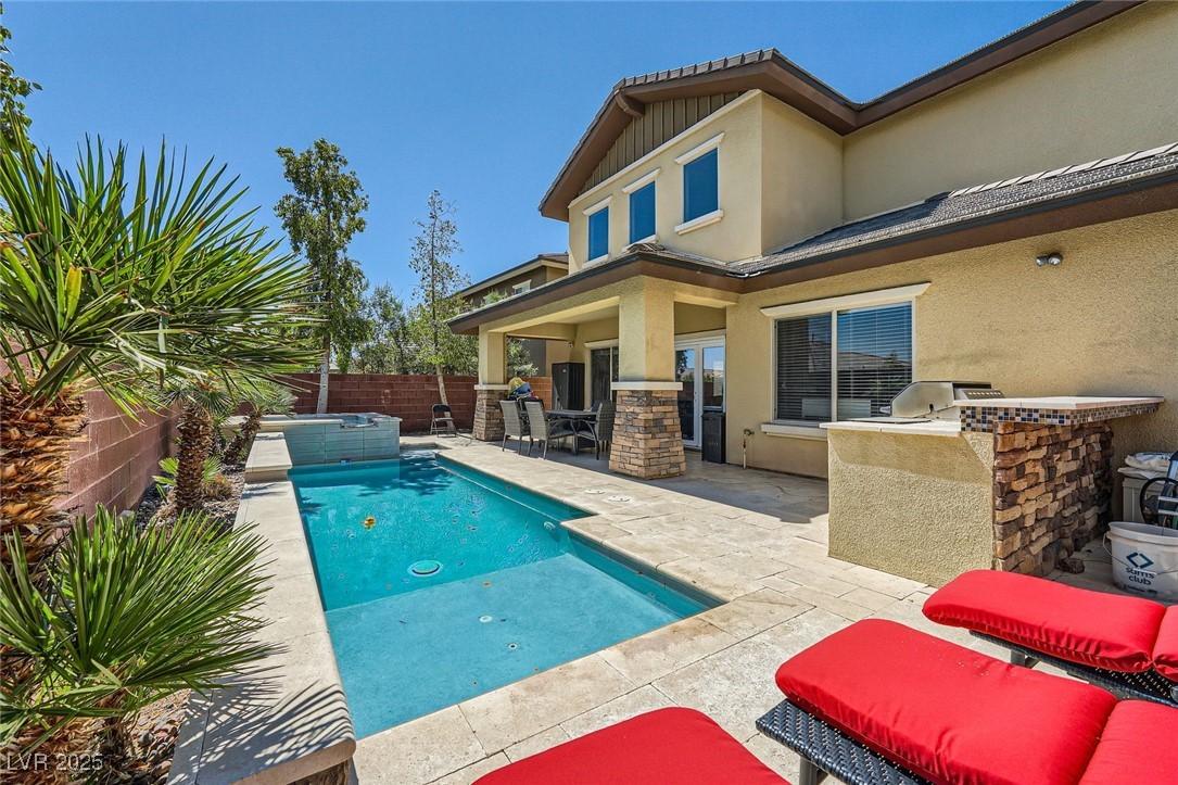 Image 1: View of pool with area for grilling, an in-ground