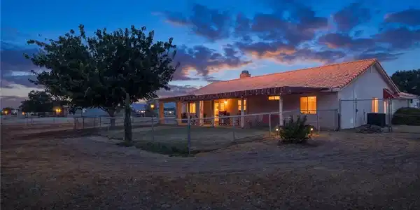 Image 2: Warmly lit patios and a tiled roof define the rear