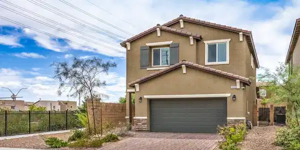 Image 3: Earth-toned stucco siding and stone accents elevat