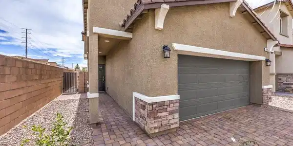 Image 4: Earth-toned stucco siding and stone accents comple