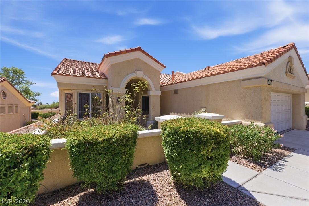 Image 2: This charming home features a classic tile roof an