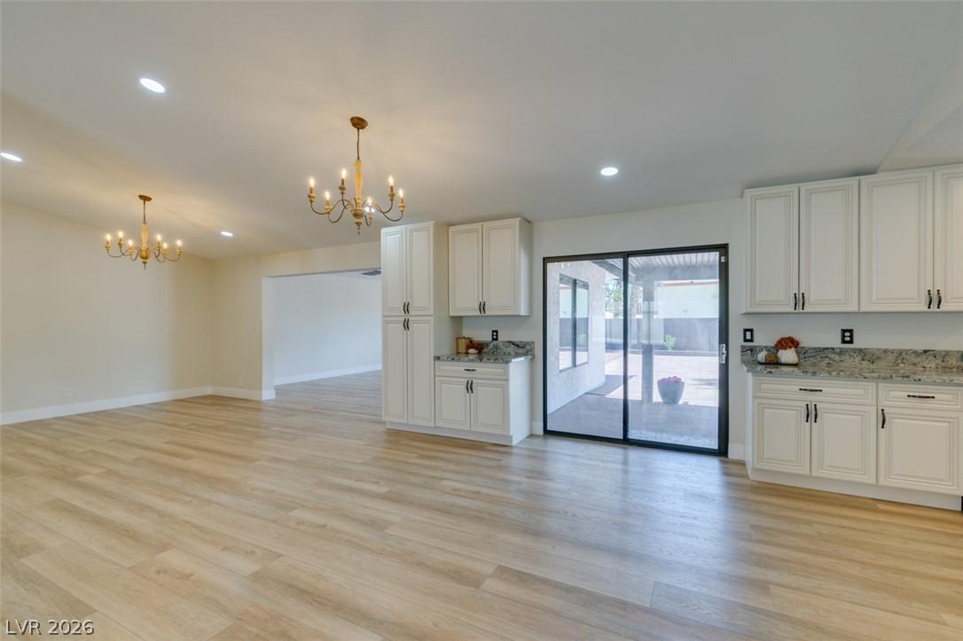 Image 4: Blonde wood flooring spans this open concept livin