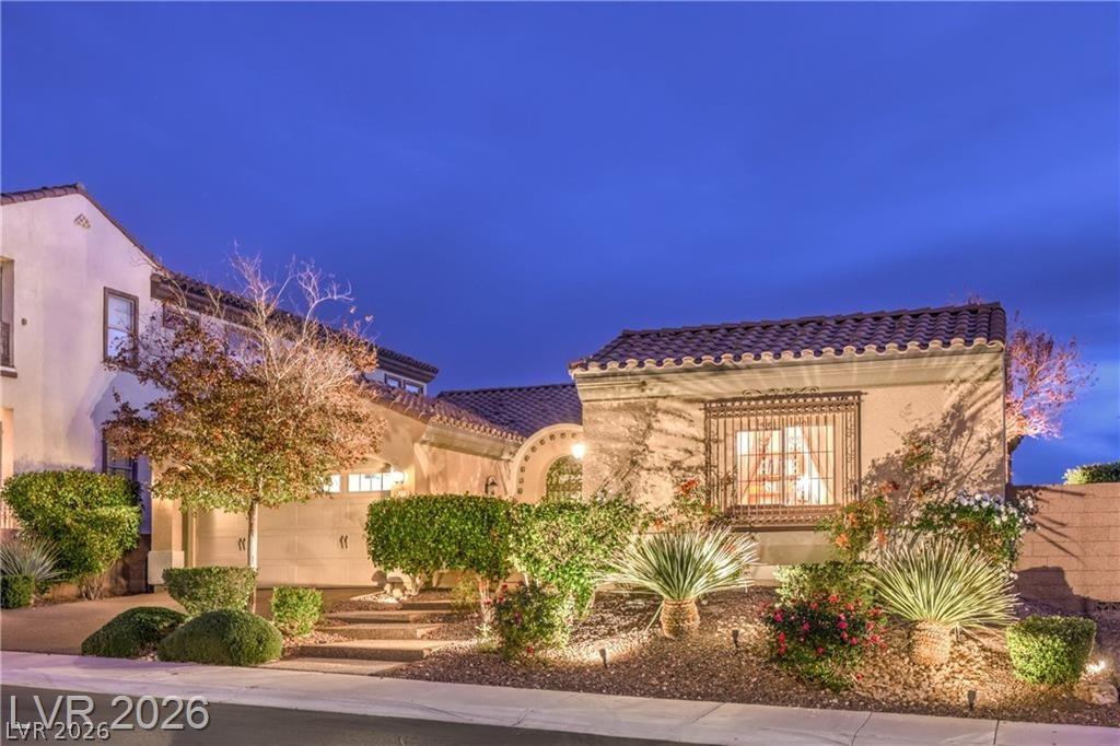 Image 2: This appealing stucco home features a tiled roof,