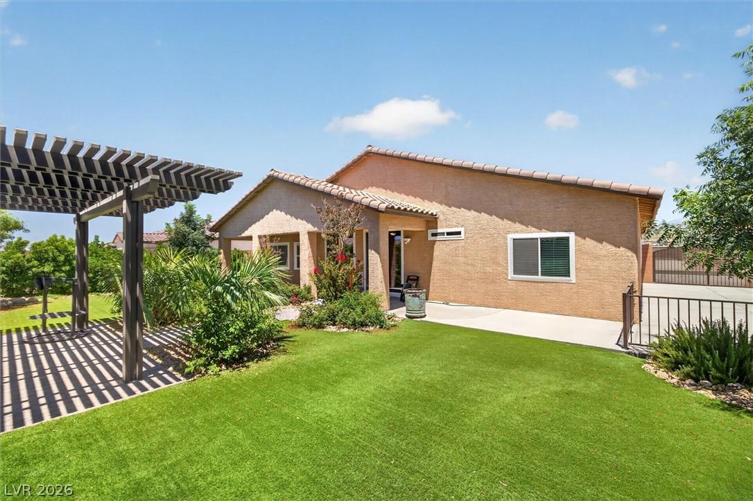 Image 2: A private, sun-drenched backyard features a pergol