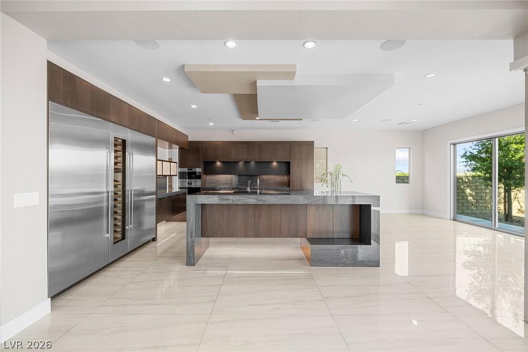 Image 3: A pristine modern kitchen features a waterfall isl