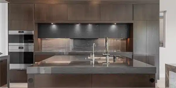 Image 4: A sleek modern kitchen with dark wood cabinetry an