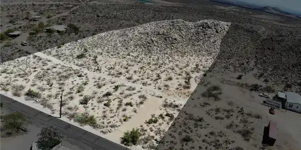 Image 3: Aerial view of sparsely populated area with a dese