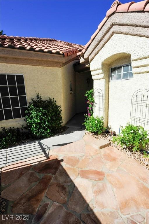 Image 3: Property entrance featuring a tiled roof and stucc