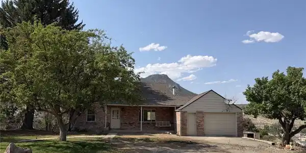 Image 2: A classic brick exterior and attached garage offer