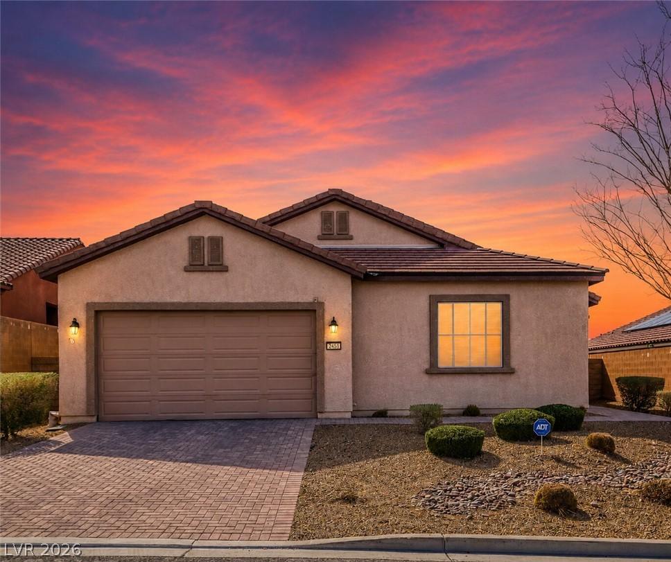 Image 1: An inviting entry showcases a paved driveway and l