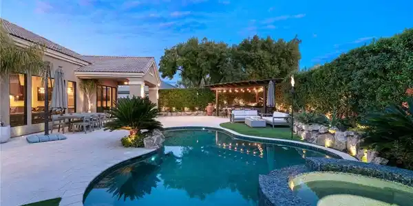 Image 2: An inviting backyard oasis features a glistening s