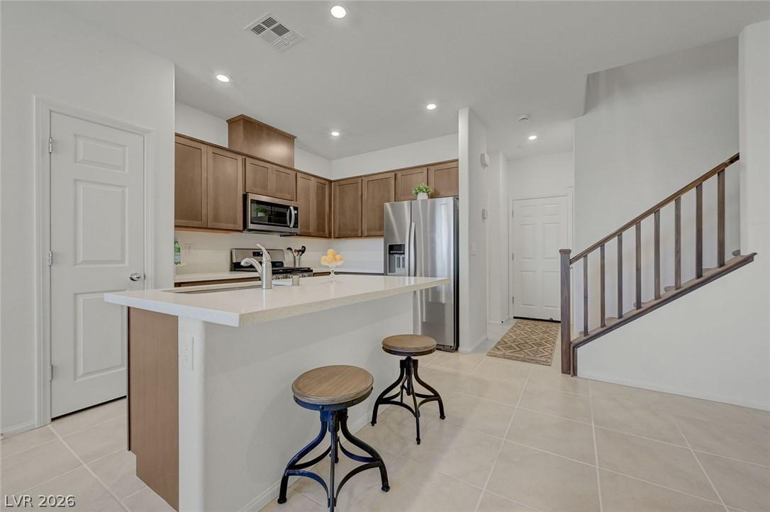Image 3: Kitchen featuring a center island with sink, stain