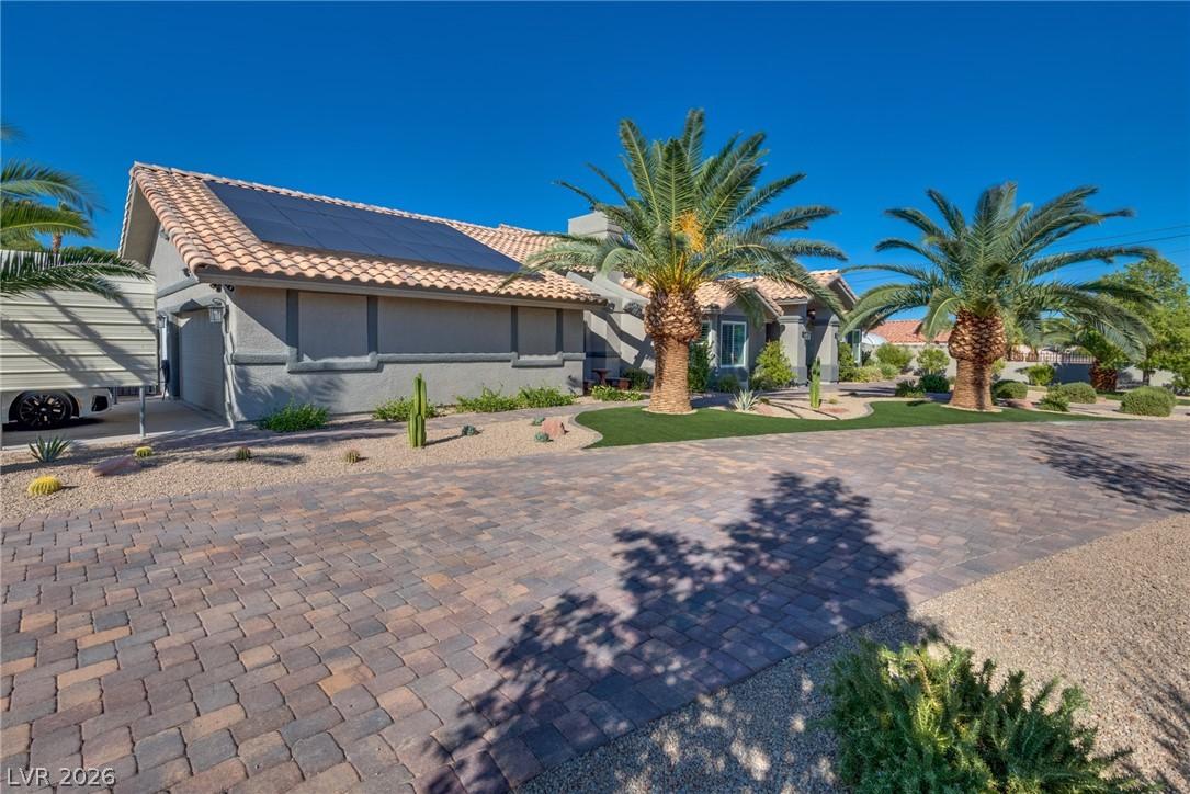 Image 3: This desert oasis features a paver driveway, lush