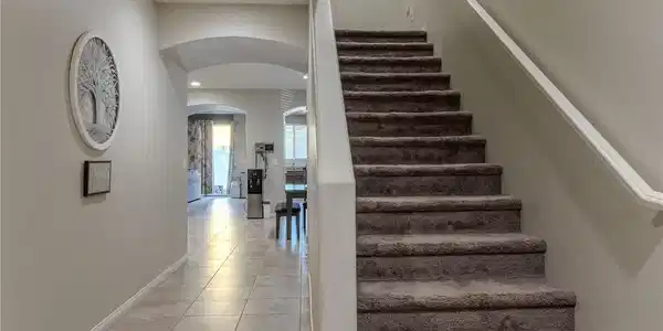 Image 3: This inviting hallway features a grand staircase a