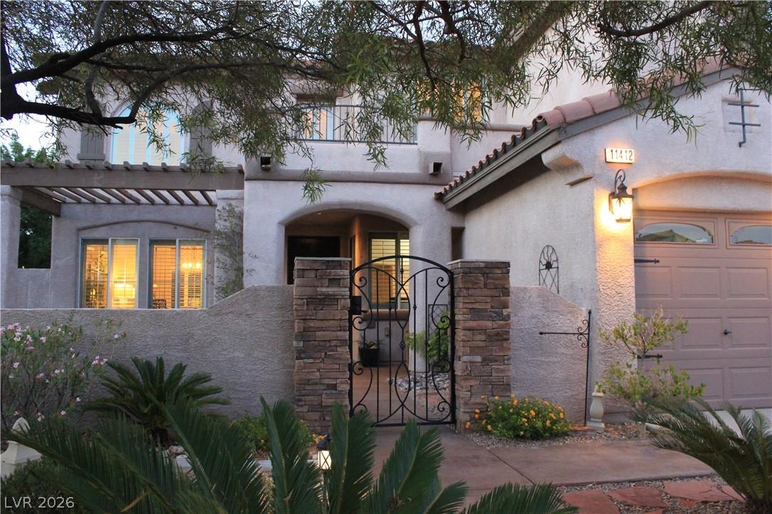 Image 2: Ornate wrought iron gate and stone pillars lead to