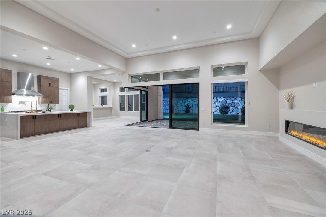 Image 1: A grand great room features a modern kitchen, slid