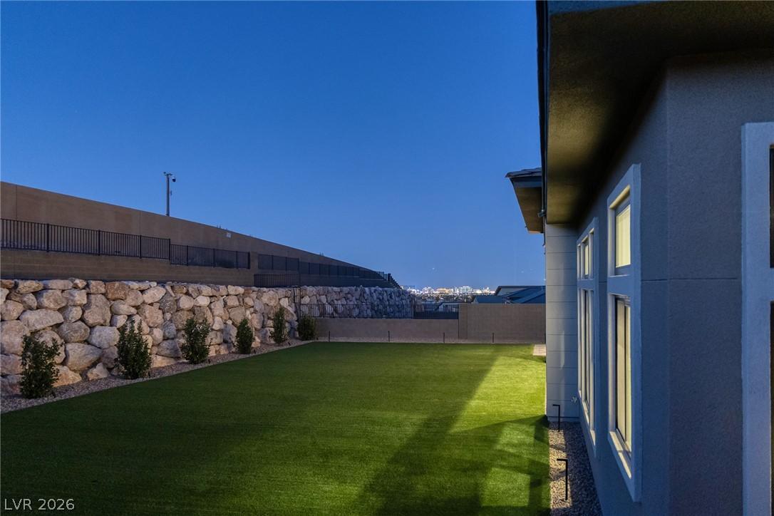 Image 4: A manicured yard with stone retaining walls, leadi