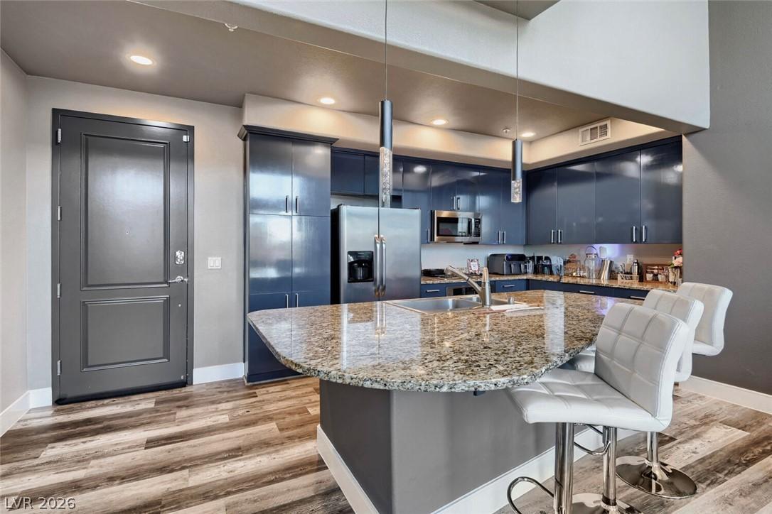 Image 2: Granite counters and wood-look flooring enhance th