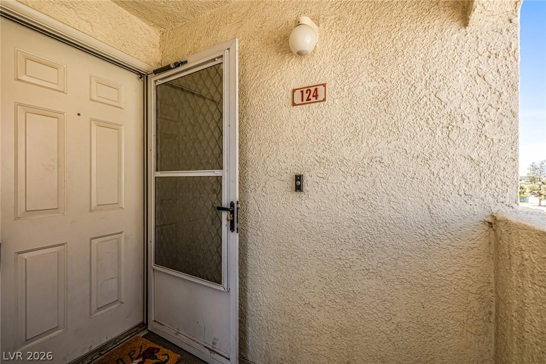 Image 4: View of exterior entry featuring stucco siding