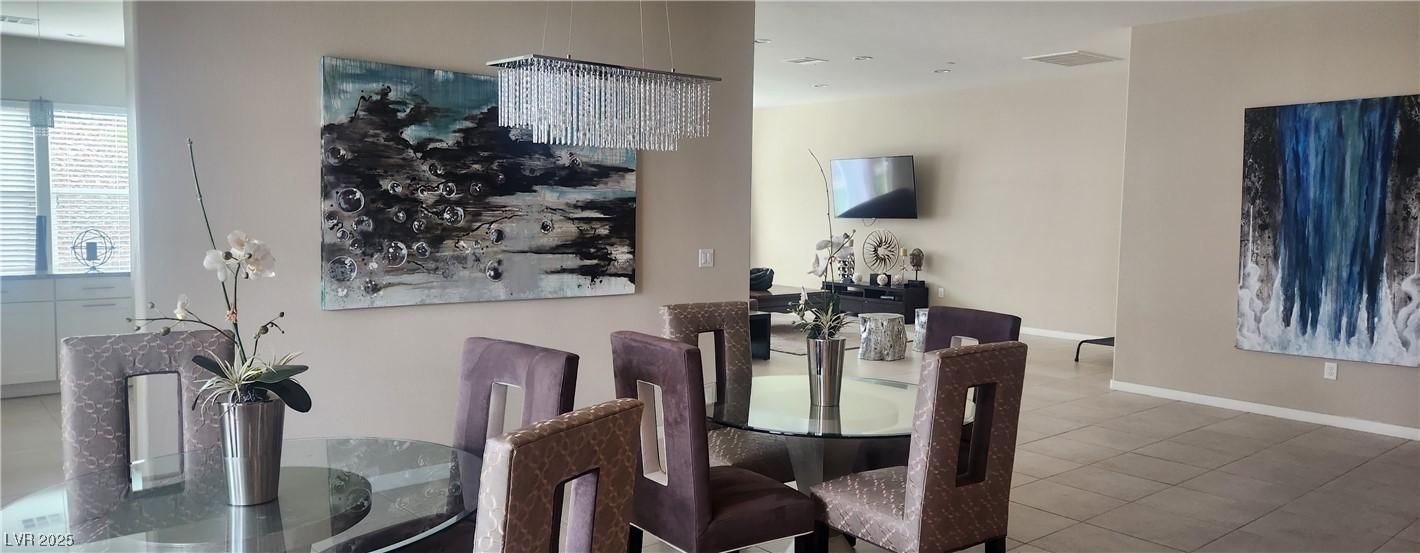 Image 3: Dining space with a chandelier and tile patterned