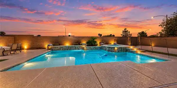 Image 3: An inviting backyard pool and integrated spa sit b