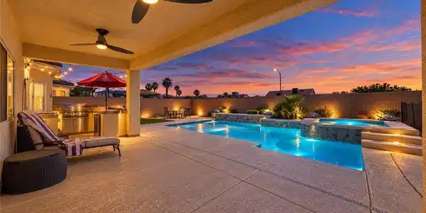 Image 4: A spacious covered patio overlooks a sparkling poo