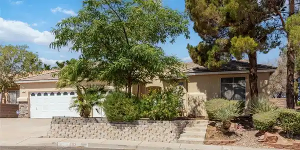 Image 2: A well-maintained stucco home with a double garage