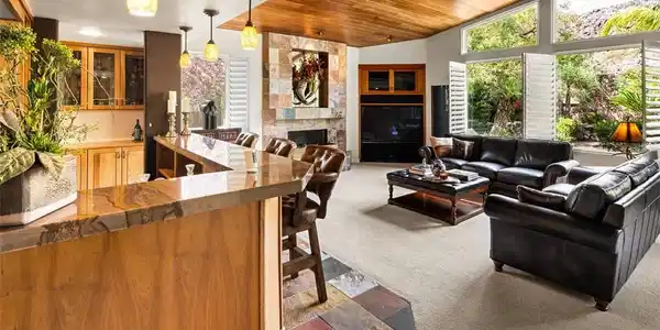 Image 4: A striking stone fireplace and wet bar complement
