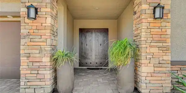 Image 4: A grand entry features stacked stone pillars frami