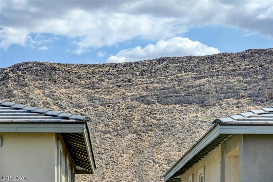 Image 4: Framed by residential rooftops, an imposing mounta
