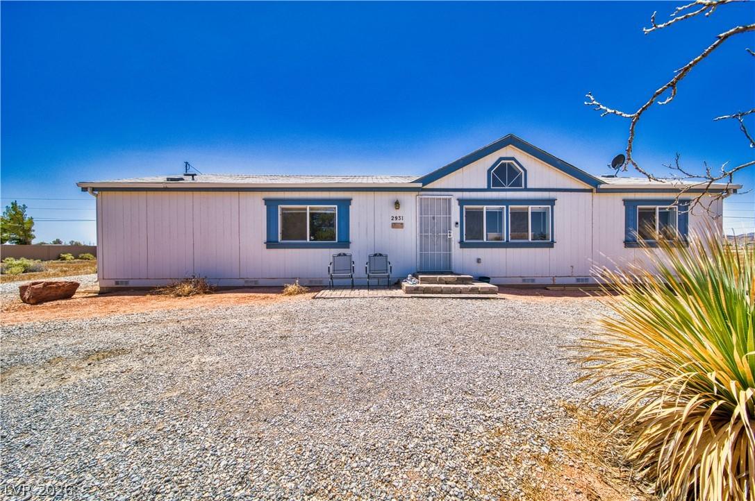 Image 2: A modest desert residence, featuring a gravel driv