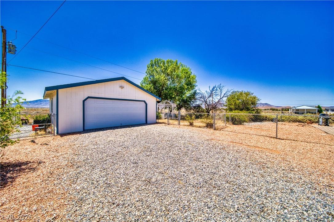 Image 3: A detached garage with ample gravel parking offers