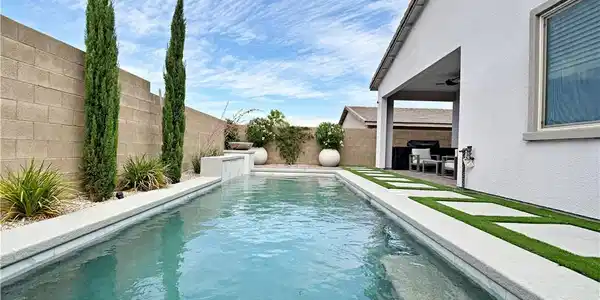 Image 2: An inviting backyard oasis features a sparkling po