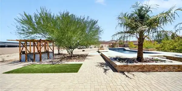 Image 2: An inviting backyard oasis features structured sto