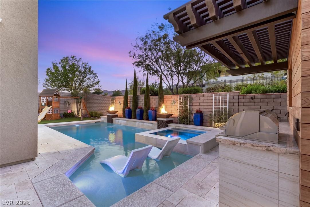 Image 3: An inviting pool area with built-in spa, outdoor k