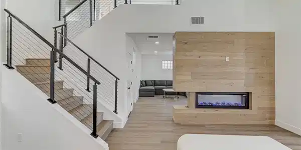 Image 4: An open staircase and contemporary fireplace highl