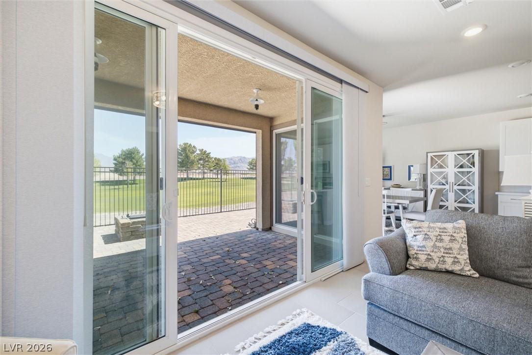 Image 3: Sliding glass doors open to a paver patio with swe